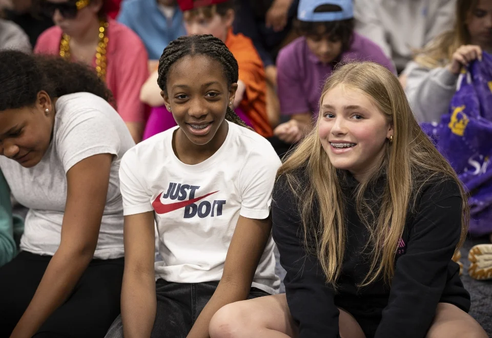 2 students sitting together and smiling