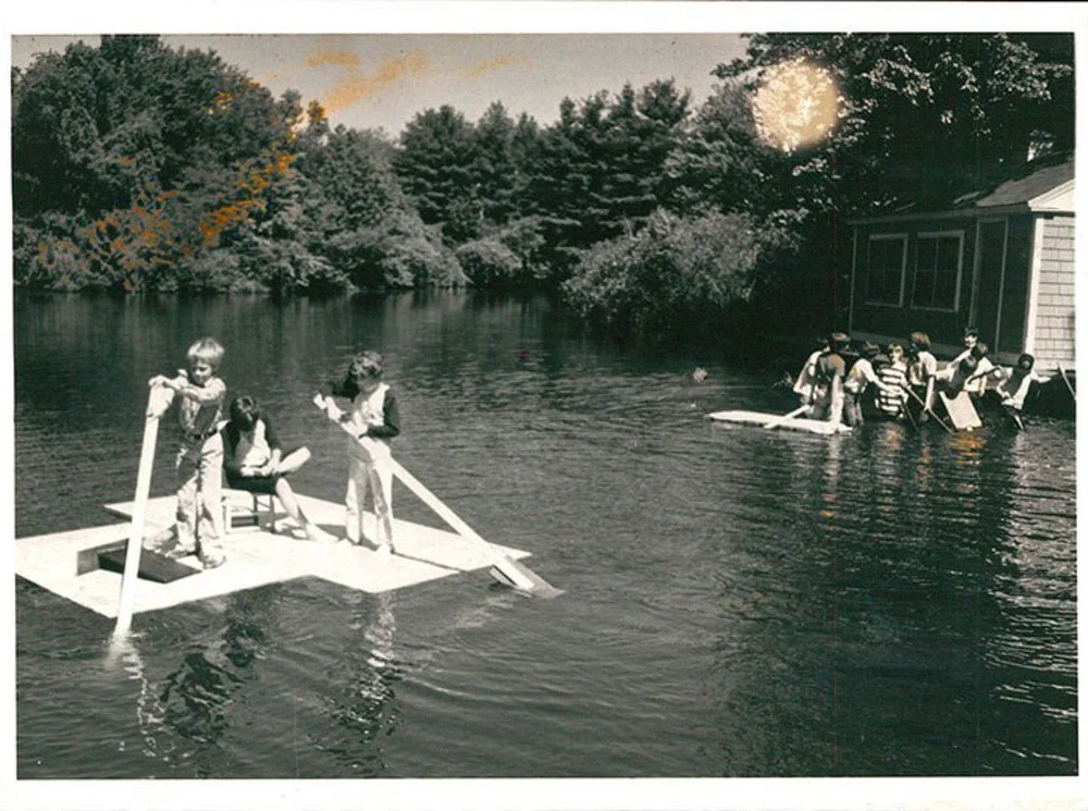old photo of Meadowbrook students paddleboarding in a lake