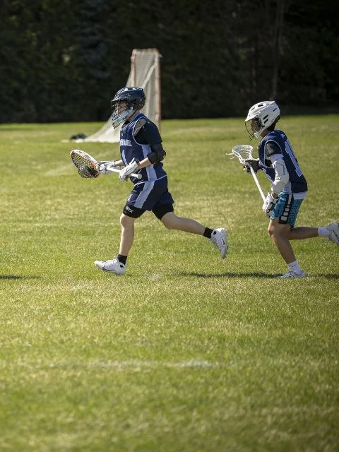 students playing lacrosse on outdoor field