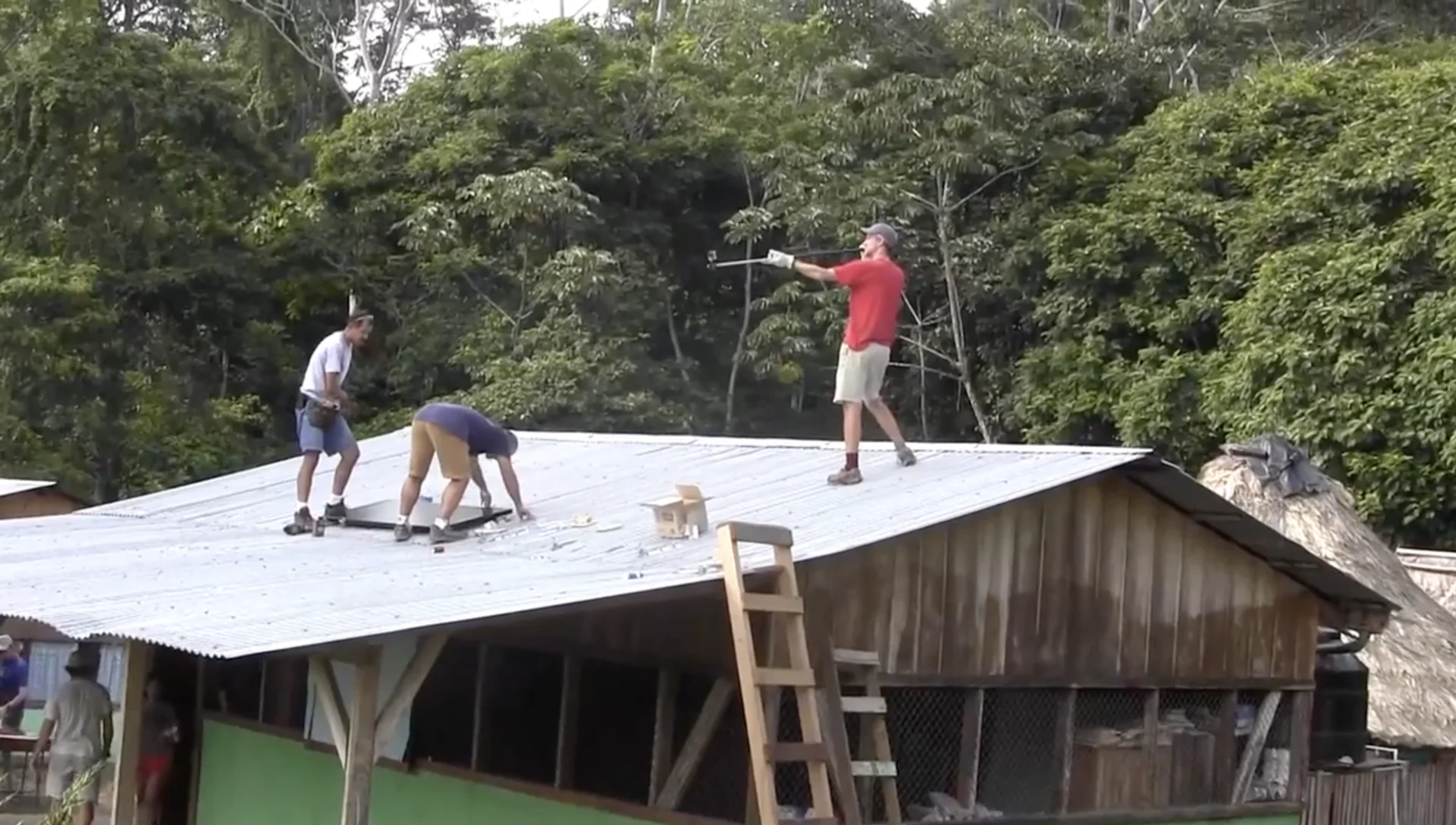 3 people installing solar panel on a roof