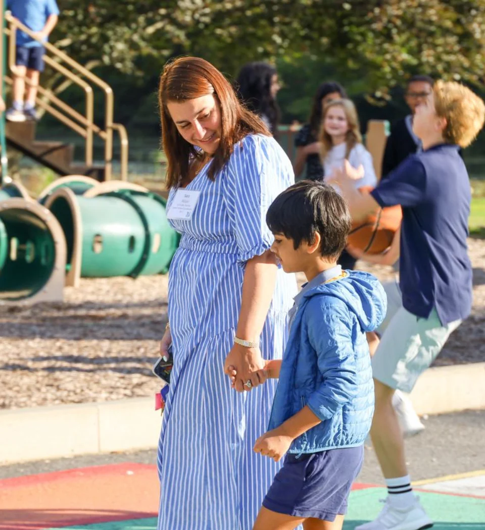 Teacher walking with student while holding his hand
